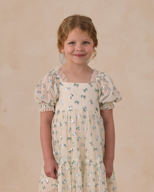 Noralee Louella dress featuring sequin bows, stylish and elegant for special occasions, showcased on a model.