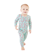 Load image into Gallery viewer, Baby wearing a festive onesie with candy cane pattern in front of a Christmas wreath.