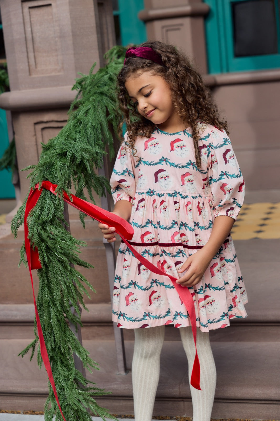 Girls Maribelle dress in Santa Garland pattern by Pink Chicken, featuring festive red and green holiday print, suitable for special occasions.