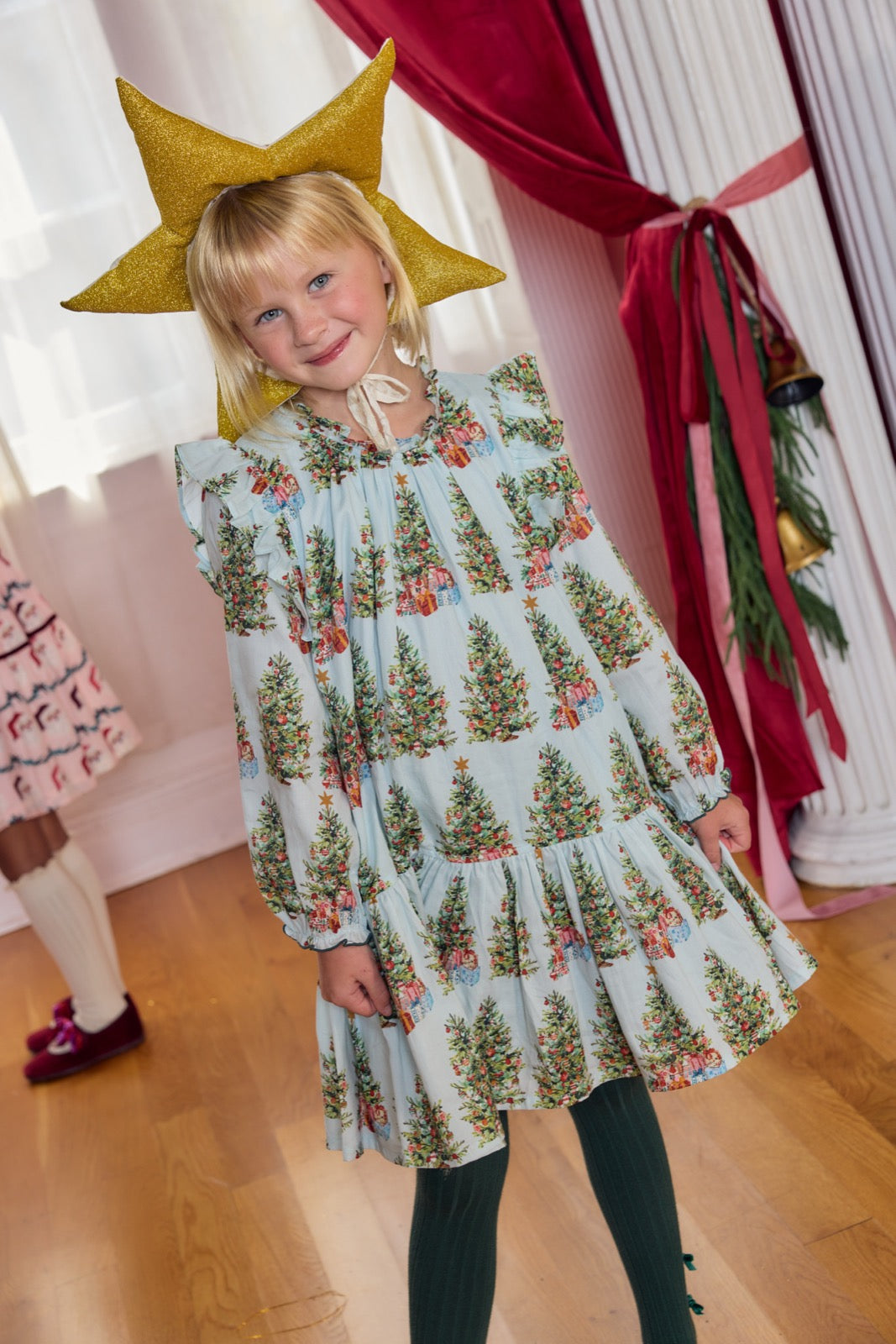 Girls Harper dress by Pink Chicken featuring a Trees and Presents print, with colorful festive holiday design and soft fabric.
