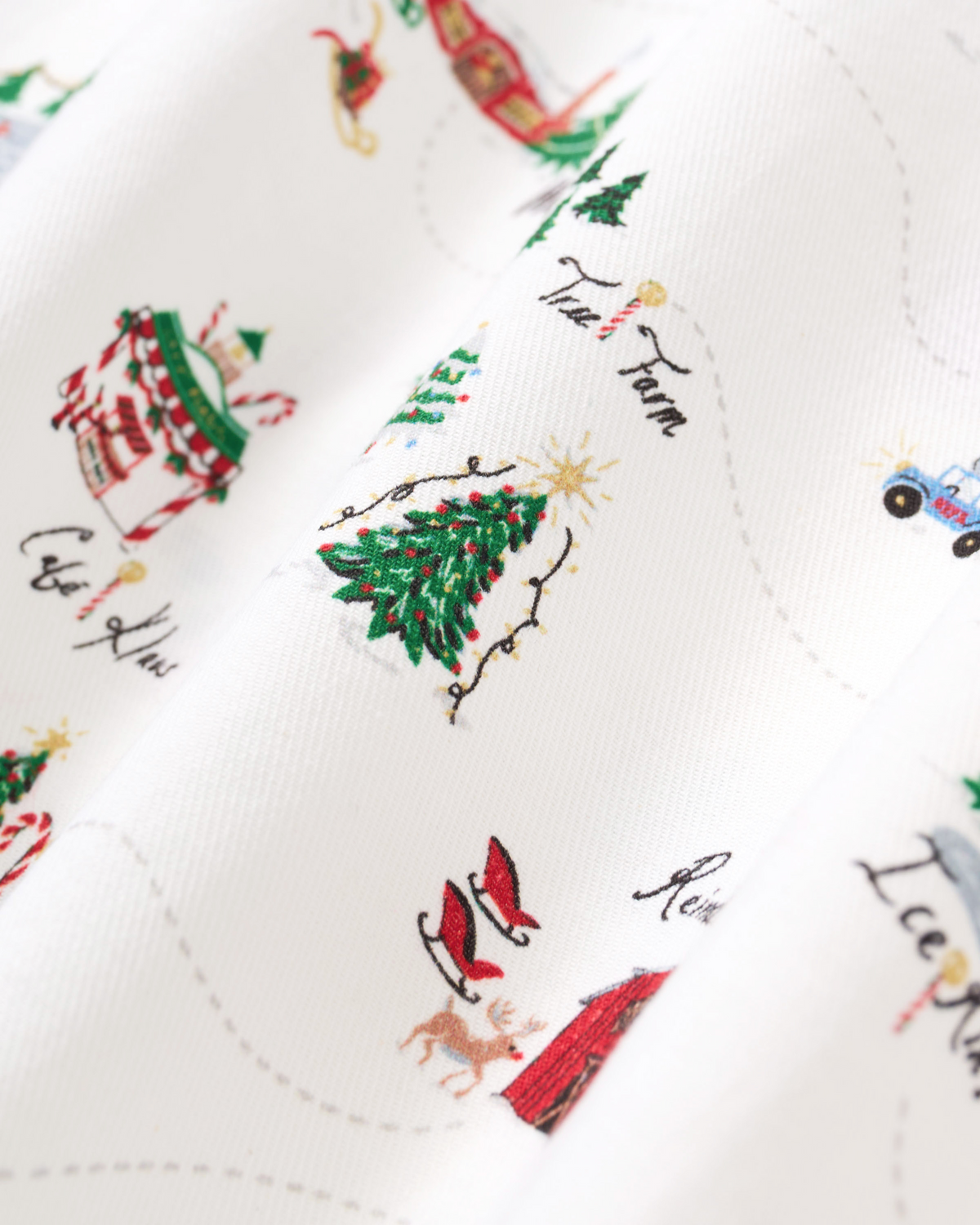 Close-up of Petite Plume Kid's Twill Pajama Set in North Pole Chronicles, showing soft fabric and festive holiday print.