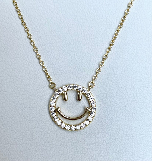 Close-up of Jack and Jewelz open happy face pendant with a cheerful smile, showcasing the jewelry's bright, polished silver finish.