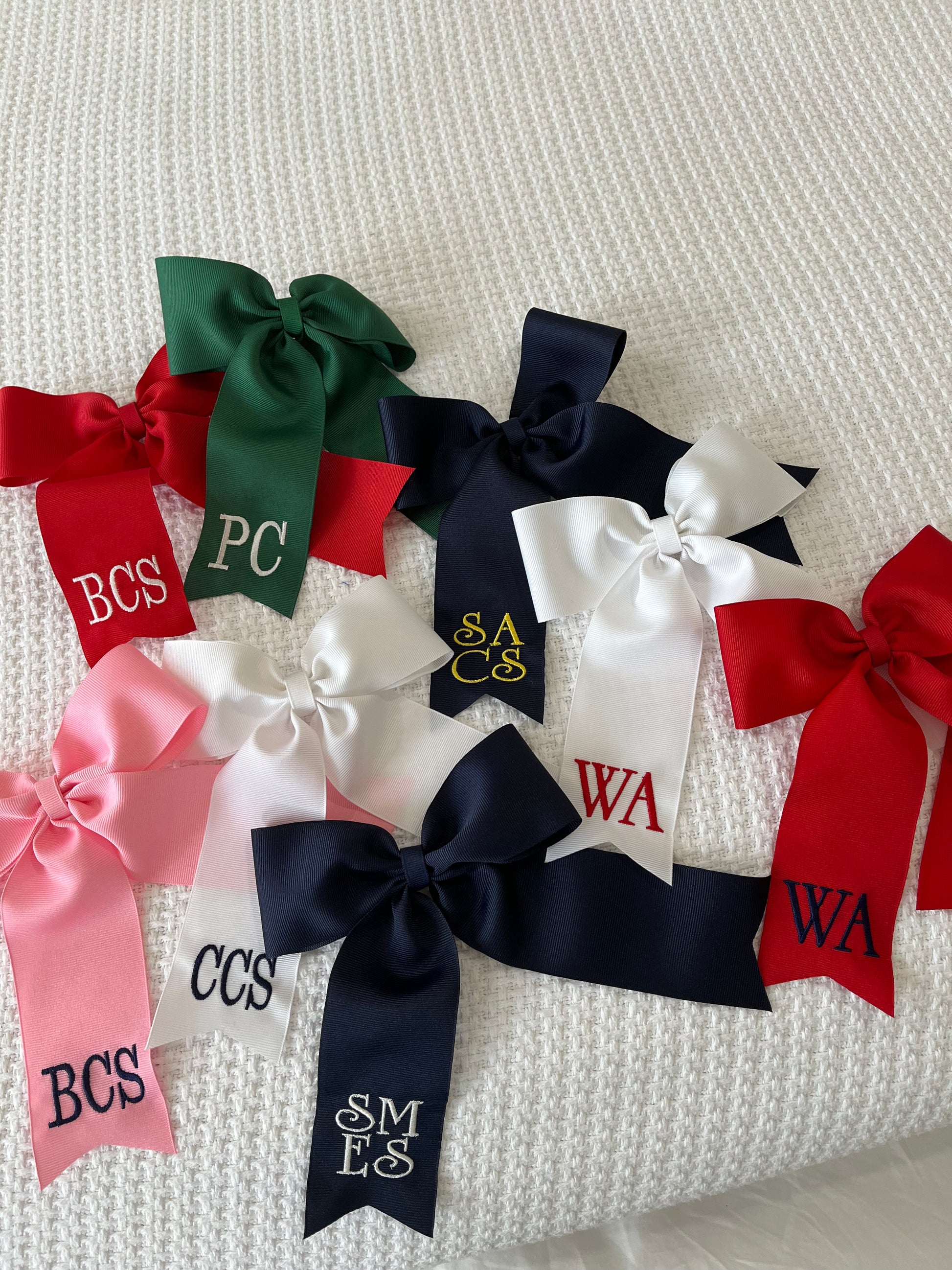 Large personalized embroidered bow with alligator clip by Flora Ottimer, featuring vibrant colors and intricate embroidery.