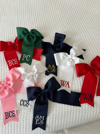 Large personalized embroidered bow with alligator clip by Flora Ottimer, featuring vibrant colors and intricate embroidery.