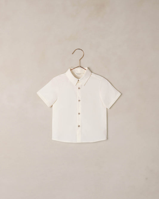 Boy wearing Noralee Atlas shirt in ivory, casual long-sleeve shirt with button details, front view.
