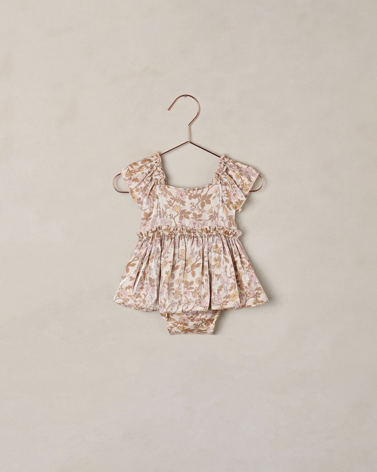 Baby girl Noralee Margot Romper in Wildflower print, featuring soft fabric and floral design, suitable for warm weather.
