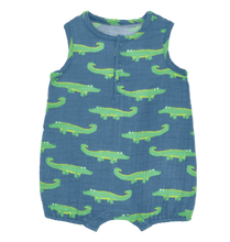 Load image into Gallery viewer, A sleeveless baby romper in blue muslin fabric with a repeating pattern of green alligators, featuring a short button placket at the neckline.

