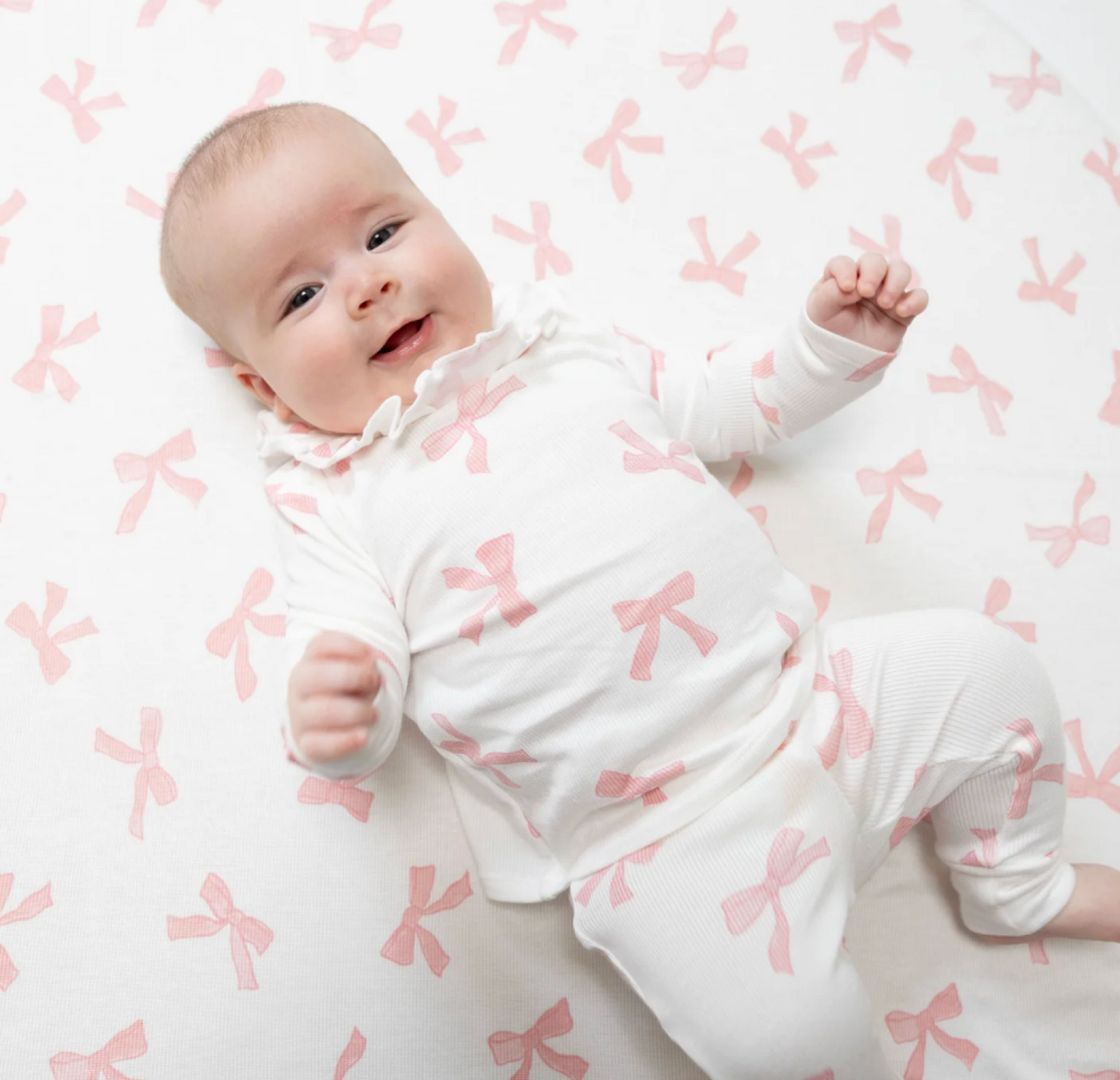 Baby girl wearing a long sleeve ruffle top and matching pants set by Angel Dear, featuring soft fabric and adorable design.
