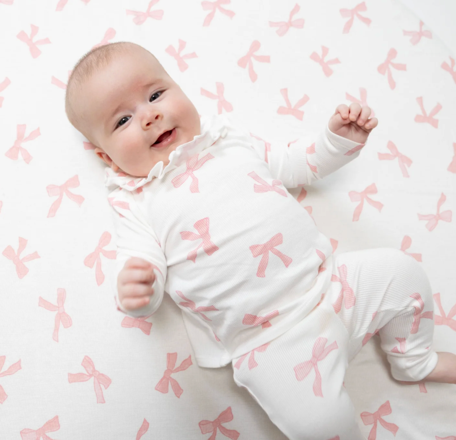 Baby girl wearing a long sleeve ruffle top and matching pants set by Angel Dear, featuring soft fabric and adorable design.