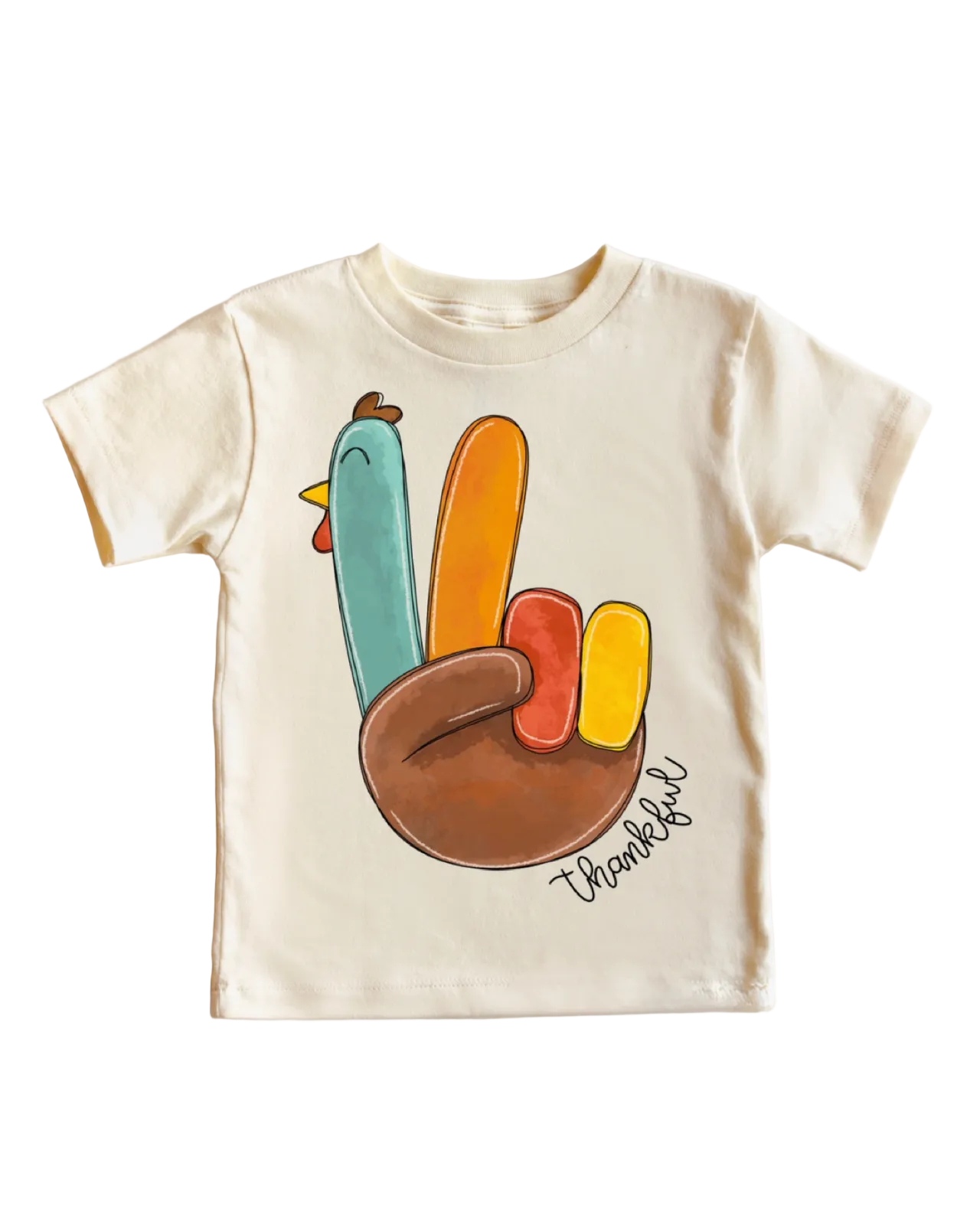 A cream-colored short-sleeve t-shirt featuring a colorful graphic of a hand making the Thanksgiving peace sign, with a turkey body and the word 'thankful' written in script.