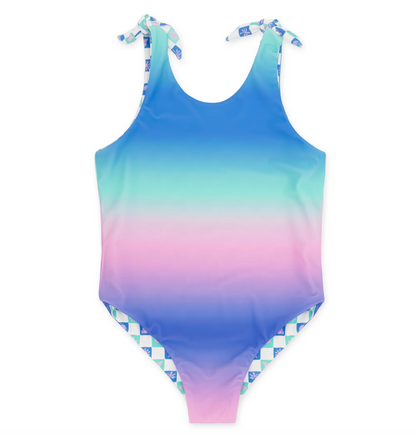 Feather 4 Arrow Skye reversible one-piece swimsuit with floral and solid patterns, shown on a model in a sunny outdoor setting.