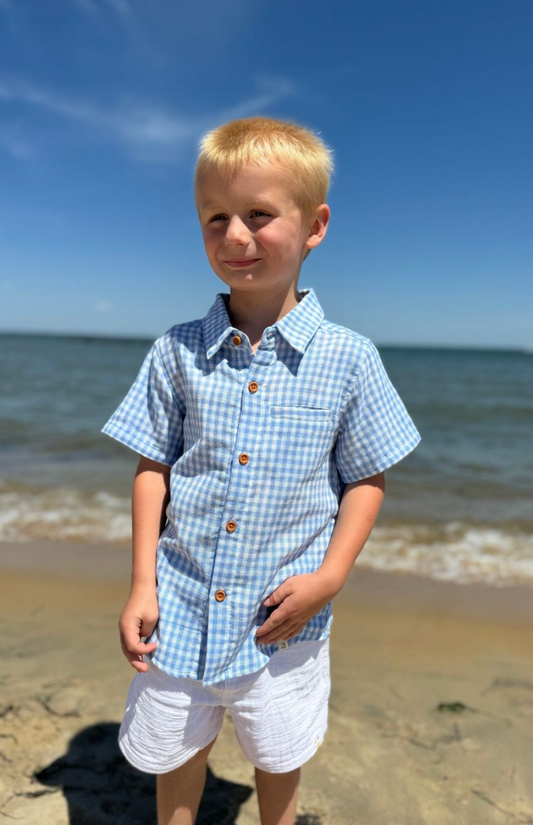Boy wearing a Me & Henry Newport woven plaid gauze shirt, featuring a classic blue and red checkered pattern.