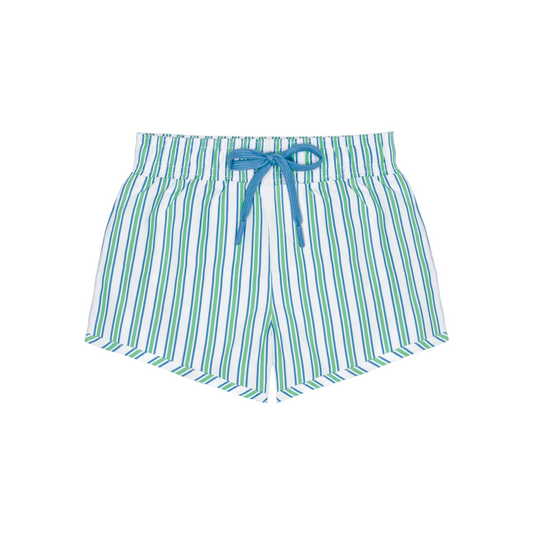 Boy wearing Minnow Tamarin Stripe Boardie with blue and white horizontal stripes, standing on the beach.