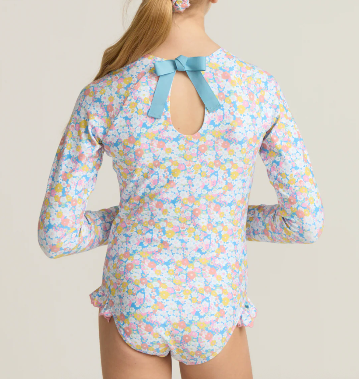Girls Minnow Jasmine Blossom rashguard one-piece swimsuit with floral pattern, featuring short sleeves and a comfortable fit.