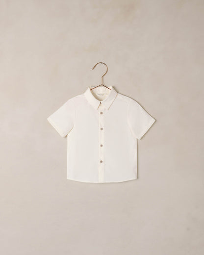 Boy wearing Noralee Atlas shirt in ivory, casual long-sleeve shirt with button details, front view.