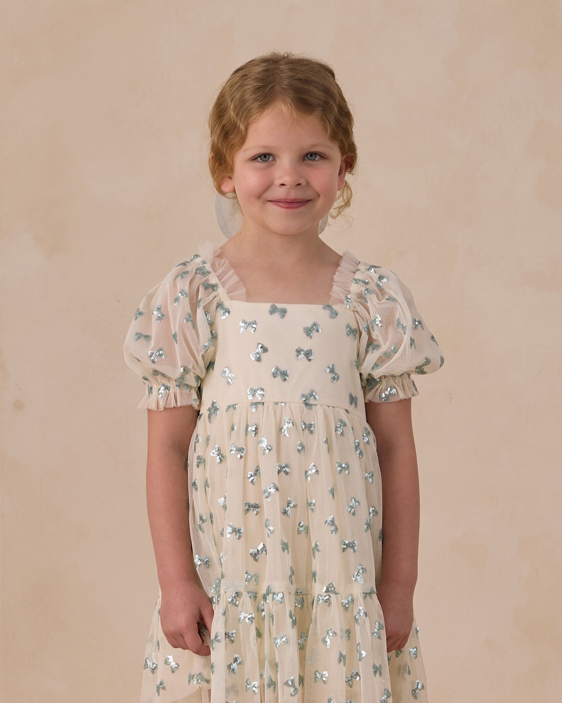 Noralee Louella dress featuring sequin bows, stylish and elegant for special occasions, showcased on a model.