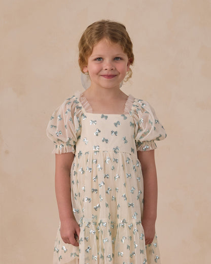 Noralee Louella dress featuring sequin bows, stylish and elegant for special occasions, showcased on a model.