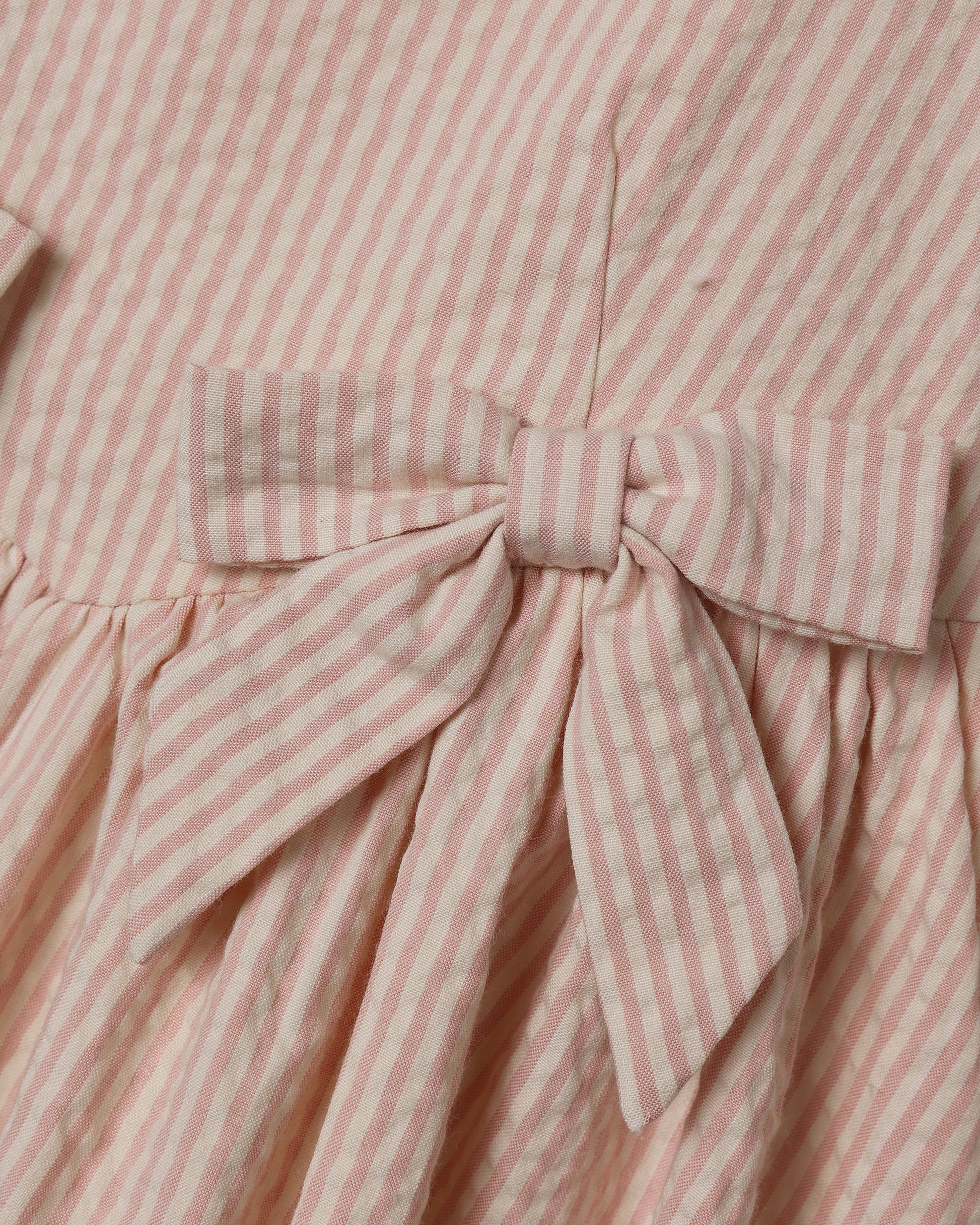 Girls Beatrice Midi Dress in Petal Pink by Noralee, showing a soft pink dress with floral details on a young girl model.