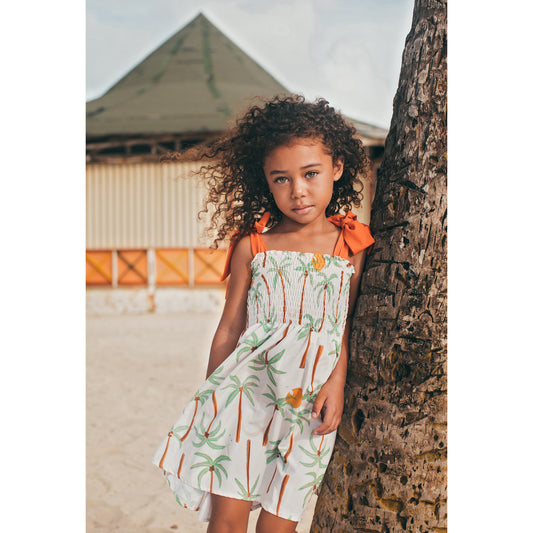 Pepita & Me Palmeras smocked dress for girls with ruffled sleeves and colorful palm leaf print on lightweight fabric.