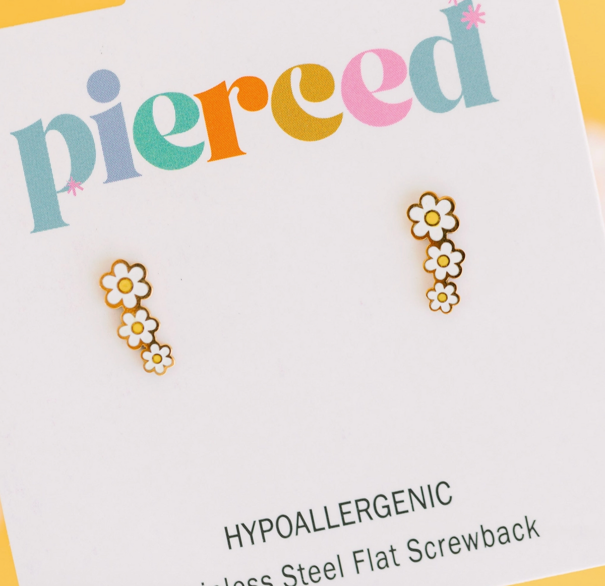 Child wearing Daisy Crawler hypoallergenic earrings from Pierced Co, featuring cute floral design for kids' sensitive ears.