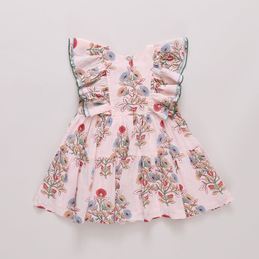 Girls Raphaela floral dress by Pink Chicken with colorful bouquet pattern, shown with flats on a resort setting.