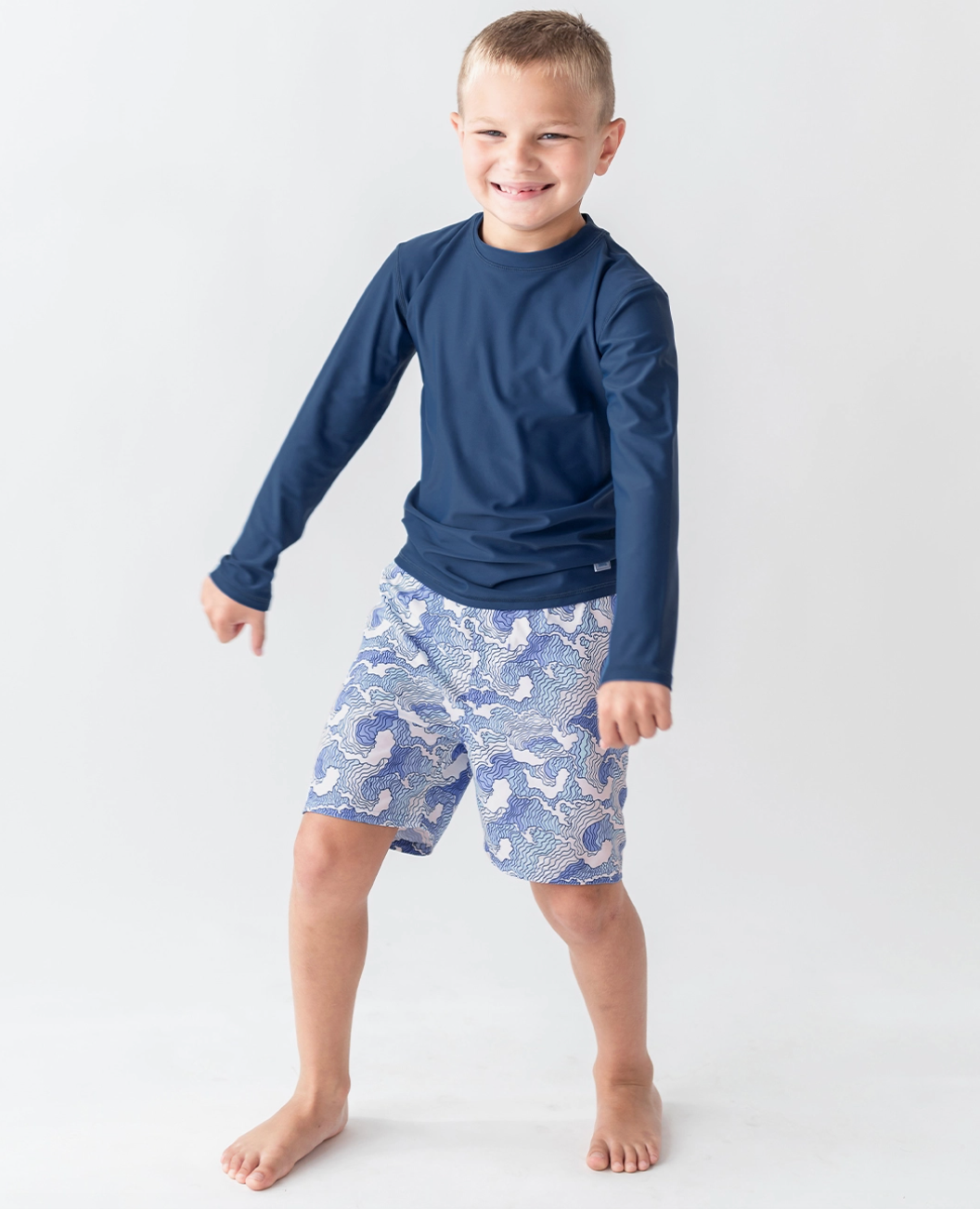 Kids navy long sleeve rash guard by Ruffle Butts, featuring a comfortable fit and sun protection for active children.