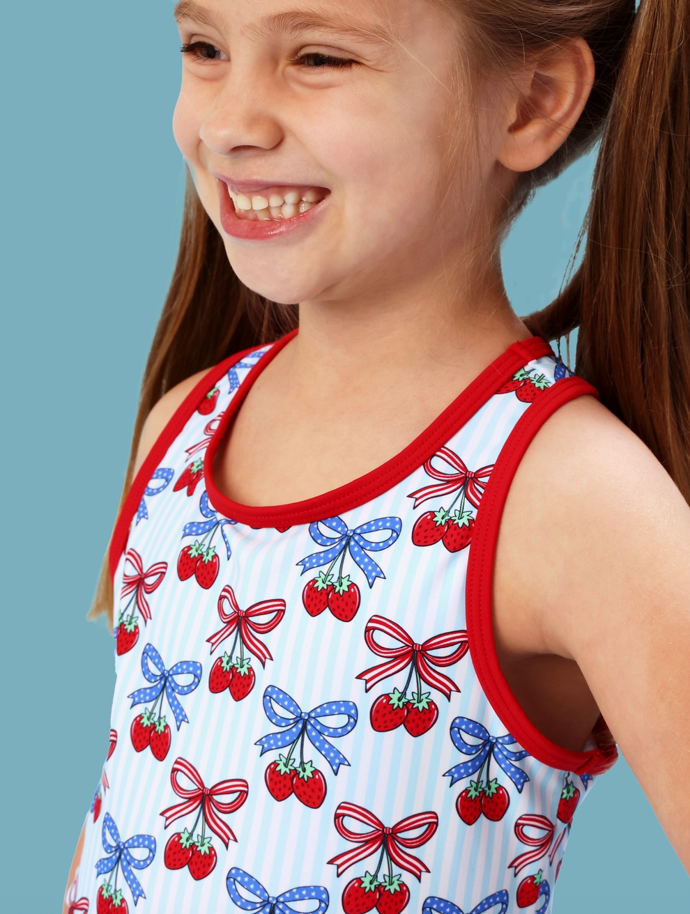 Girls Berries & Bows pleated skirt and active dress set with bike shorts by Ruffle Butts, featuring a colorful berry and bow pattern.