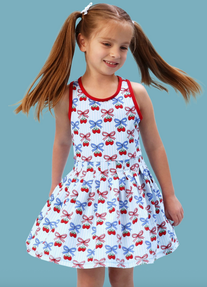 Girls Berries & Bows pleated skirt and active dress set with matching bike shorts, featuring a playful berry and bow pattern by Ruffle Butts.