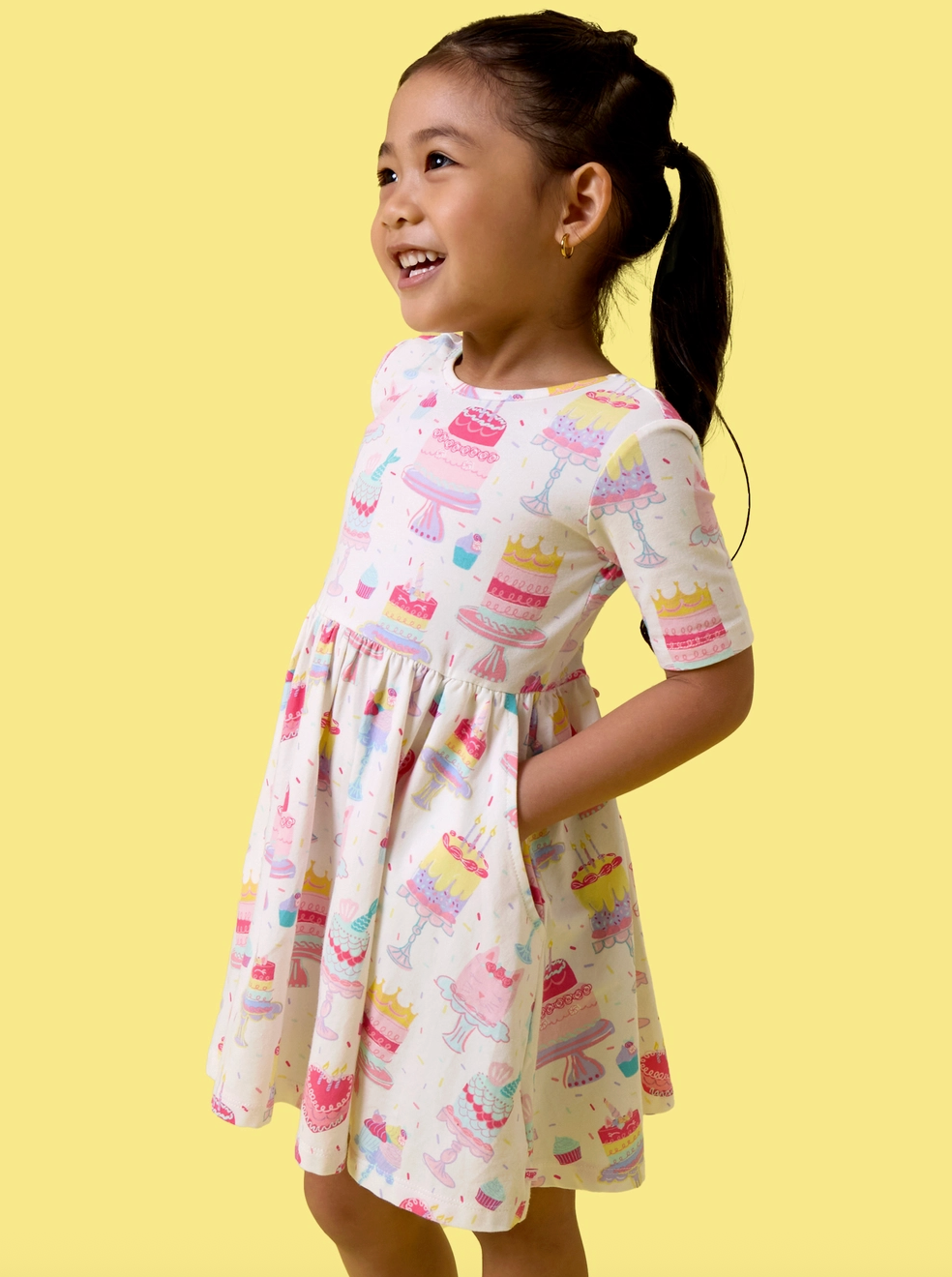 Girls birthday cake party dress by Ruffle Butts, short sleeve knit twirl dress with colorful cake print for special celebrations.