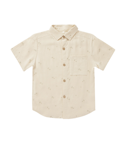 Boy wearing Rylee & Cru palm print collared shirt with short sleeves, featuring a vibrant tropical pattern and classic collar style.