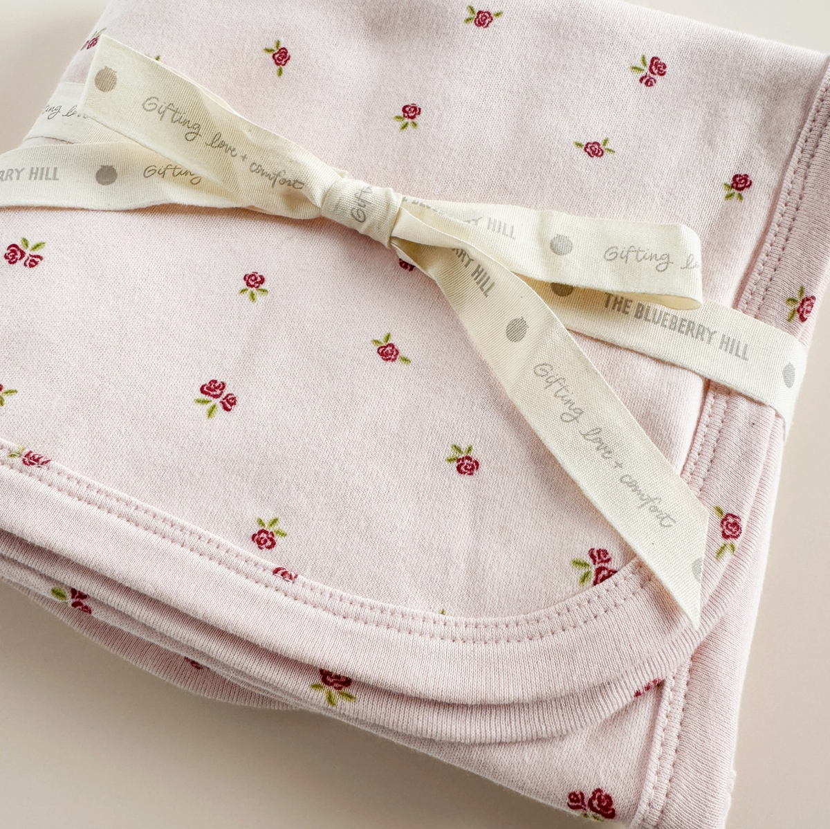Pink strawberry and rose-themed layette set for newborns by The Blueberry Hill, including soft clothing for baby girls.