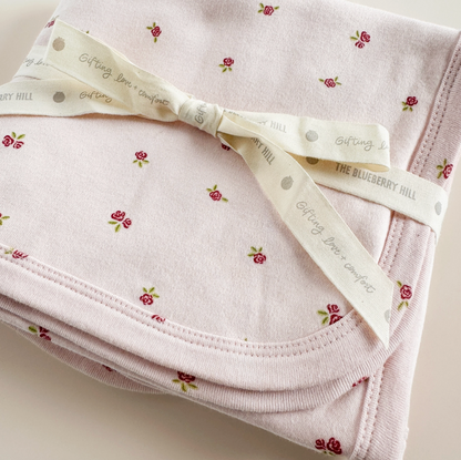 Pink strawberry and rose-themed layette set for newborns by The Blueberry Hill, including soft clothing for baby girls.