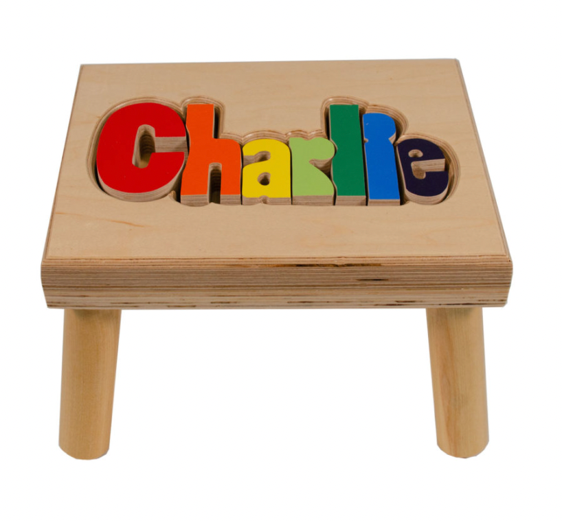 Custom Flora Ottimer Classic Puzzle Name Stool with colorful puzzle piece design and personalized name on a wooden seat.