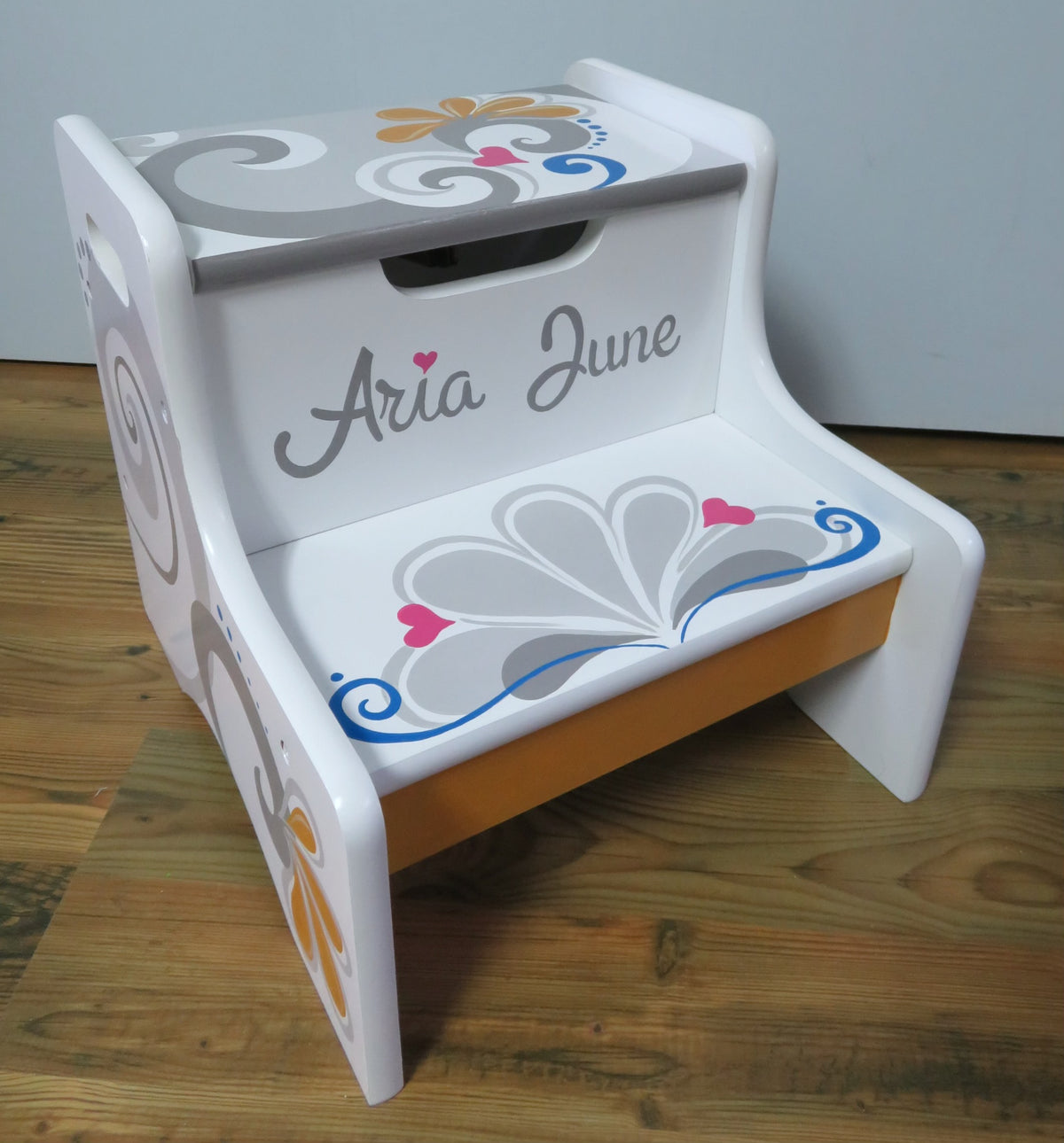 Hand painted 2-step stool by Flora Ottimer featuring colorful floral designs and sturdy wooden construction.