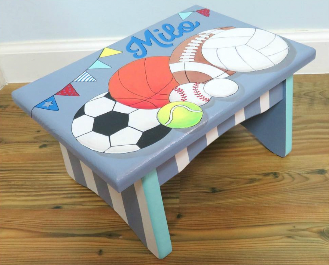 Custom hand-painted foot stool by Flora Ottimer featuring vibrant floral artwork and detailed craftsmanship.