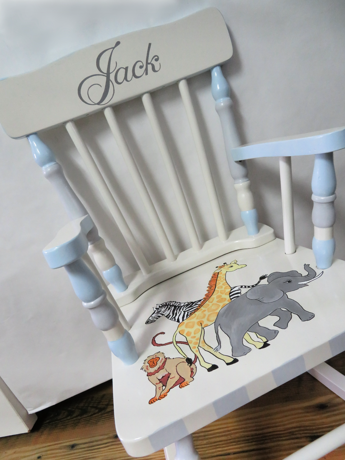 Hand-painted wooden rocking chair by Flora Ottimer with colorful floral designs, showcasing detailed craftsmanship and artistic decor.