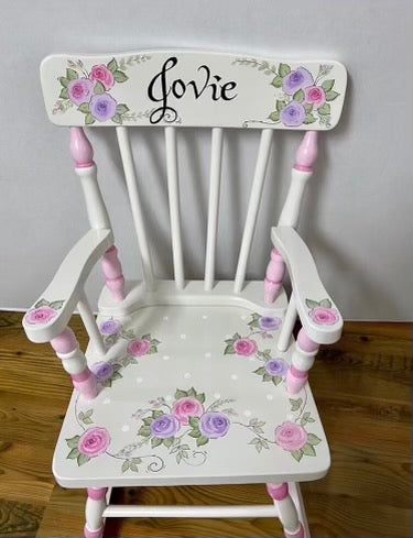 Hand-painted wooden rocking chair by Flora Ottimer, featuring intricate floral designs and a classic rocking chair silhouette.